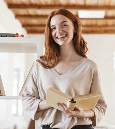 happy-redhead-young-lady-student-reading-book-M5Z7RVC.jpg